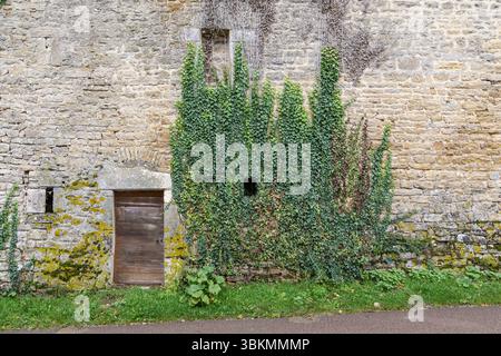 CHATEAUNEUF, FRANKREICH - 29. OKTOBER 2023: Dies ist ein Fragment einer alten Steinmauer eines der Häuser mit einer Tür auf der Dorfstraße. Stockfoto