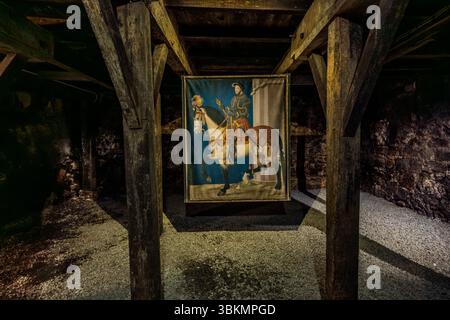 Ein großes Reiterporträt von König François Ier (Franz I.) hängt in den ehemaligen Ställen des Cognac-Schlosses (Château de Cognac), Rampe du Château, Cognac, Nouvelle-Aquitaine, Frankreich. Der König trägt eine Rüstung und reitet ein weißes Pferd mit einem roten Schabracken, das in Gold auf blauem Grund verziert ist. Das Bild hängt zwischen alten Holzpfosten über einem Kiesboden. Es basiert möglicherweise auf dem Reiterporträt von François Ier im Louvre, einer Miniatur aus der Zeit um 1540, die Jean Clouet zugeschrieben wird. Der König galt als gutaussehend und war für seine Zeit ein großer Mann. Politisch war er nicht sehr erfolgreich: h Stockfoto