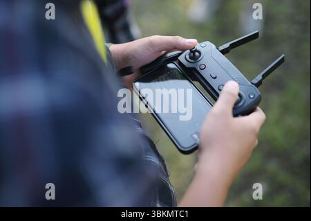 Der junge Mann hält seinen Drohnenkontrolleur fest Stockfoto
