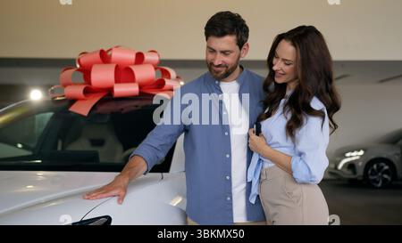 Glückliche kaukasische Familie, die neues Auto kauft Luxusauto wählt Sprechen Sie Paare Mann mit Frau wählen Sie Transport in Auto Salon Showroom mieten Stockfoto
