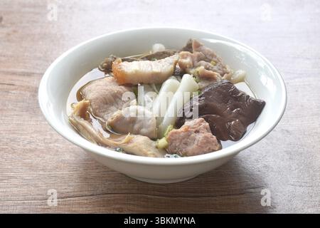 Große Reisnudeln hacken und knuspriges Schweinefleisch mit Blut in klarer Suppe auf einer Schüssel Stockfoto
