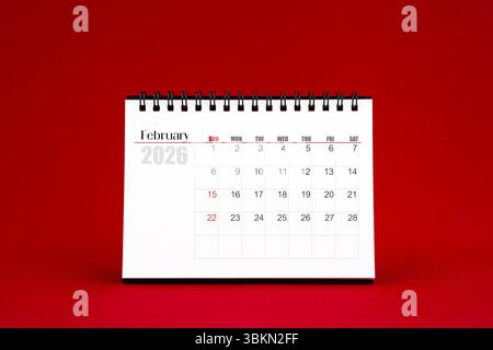 Februar 2026 leerer Schreibtischkalender auf rotem Hintergrund. Stockfoto