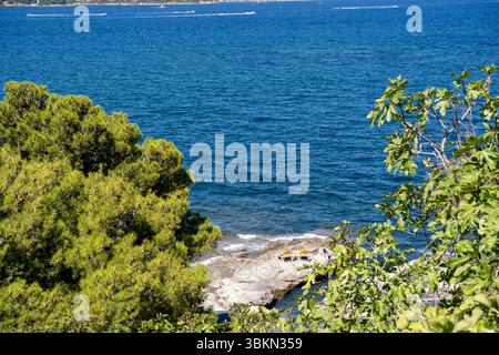 Eine malerische ruhige Meereslandschaft mit üppigem Grün und atemberaubendem klarem, blauem Wasser Stockfoto