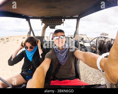 Zwei Freunde bereiten sich auf eine aufregende Offroad-Fahrt in der Wüste vor. Sie sind für Abenteuer gekleidet und bereit, das sandige Gelände zu erkunden. Stockfoto