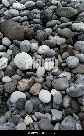 Das Bild zeigt eine Sammlung von abgerundeten Felsen in Grau- und Weißtönen, die eine beruhigende und natürliche Szene schaffen. Stockfoto
