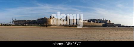 Panoramablick auf die befestigte Altstadt von Saint-Malo und die Verteidigungsanlage am Strand in der Abenddämmerung, von Plage de l'Eventail in der Bretagne aus gesehen. Stockfoto