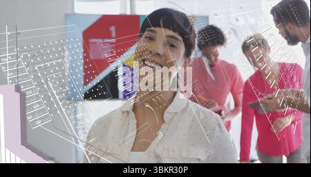 Multikulturelle Frau, die im offenen Büro steht und lächelt, mit Tablets und holografischen Überzügen Stockfoto