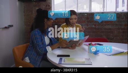 Zusammenarbeit mit zwei Kollegen beim Überprüfen des Tablets im Besprechungsraum mit Smartphones und Symbolen Stockfoto