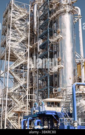 Destillationssäule und chemische Verarbeitungseinheit in einer Industrieanlage bei Tageslicht, die Effizienz und fortschrittliche Technologie demonstriert Stockfoto