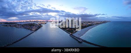 Aus der Vogelperspektive auf die nächtliche Küste von South Beach. Miami Skyline mit tropischem blauem Wasser Panorama. Panorama über die Wolkenkratzer von Miami in der Abenddämmerung. Stockfoto