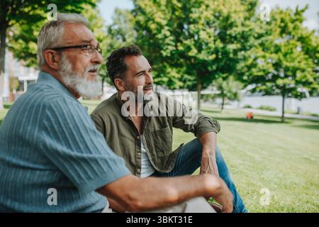 Glücklicher Vater und erwachsener Sohn genießen einen friedlichen Nachmittag im Freien Stockfoto
