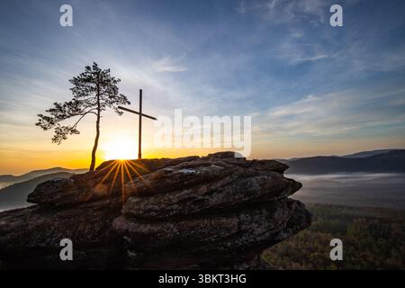 Sonnenaufgang über einer Berglandschaft. Aufgehende Sonne hinter einer Sandsteinklippe im Wald. Nebelbildung im Tal bei Rözenfelsen, Pfälzerwald, Stockfoto