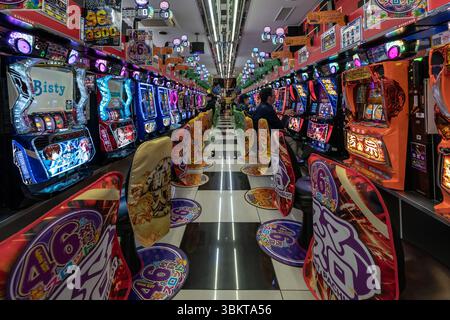 Leute in der Spielautomaten-Arcade von Pachinko in Osaka, Japan. Pachinko ist ein beliebtes Spiel für Freizeit- und Glücksspiele. Stockfoto