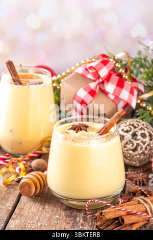 Weihnachtsgetränk mit Zimtstangen und Anissternen, zwei Gläser süßen klassischen Eierlikör-Cocktail an Weihnachten, Silvester dekoriert Hintergrund mit fi Stockfoto