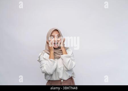 Indonesische muslimische Frauen, die Hijab tragen, sind überrascht und freuen sich. Mit einem weißen Hemd und isoliert auf weißem Hintergrund Stockfoto
