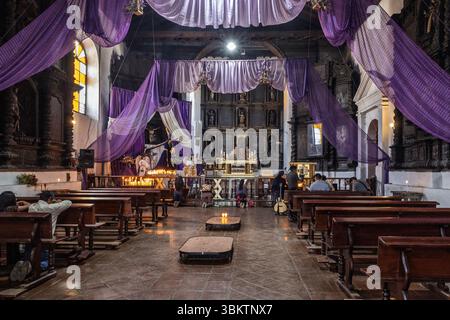 Innenraum der katholischen Kirche Iglasia de Santo Tomas, mit religiösen Maya-Ritualaltären, lila Hängen für die Fastenzeit, Chichicastenango, Guatemala Stockfoto