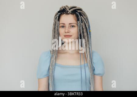 Junge lächelnde Frau aus der Nähe, die auf weißen Hintergrund blickt. Stockfoto