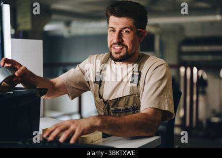 Facharbeiter, der in der Werkstatt während der Abendstunden mit Werkzeugen und Projekten praxisorientierte Übungen durchführt Stockfoto