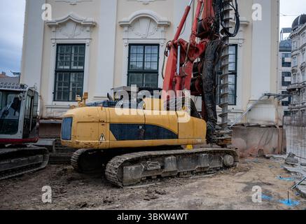 Große Raupenbohrmaschine auf der Baustelle vor der historischen Gebäudefassade Stockfoto