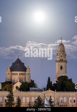Vollmond, der hinter der Dormition Abbey gleich außerhalb der Stadtmauern von Jerusalem aufsteigt Stockfoto