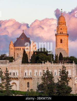 Die tief hängenden Wolken hinter der Dormition Abbey in Jerusalem werden von den letzten Sonnenstrahlen bei Sonnenuntergang beleuchtet Stockfoto