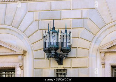 Eine Vintage Straßenlampe ziert die Wand des historischen Gebäudes und veranschaulicht die wunderschöne architektonische Eleganz. Stockfoto
