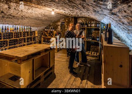 Weinkeller mit Selbstbedienung im Auberge Restaurant Chez cUL de Paille in Poitiers. Gäste gehen in den Kellerraum und wählen eine Flasche Wein für ihre Mahlzeit. Die Preise sind auf den Weinboxen angegeben. Die Gäste nehmen die Flasche selbst an ihren Tisch, wo sie vom Personal geöffnet wird. Eine der Besonderheiten der Auberge Le cUL de Paille ist, dass Gäste ihren eigenen Tafelwein im Keller wählen können und dass viele berühmte Künstler, wie Jaques Brel, sich an den Wänden mit Autogrammen, Sprüchen und Zeichnungen verewigt haben. Rue Théophraste Renaudot, Poitiers, Nouvelle-Aquitaine, Fra Stockfoto