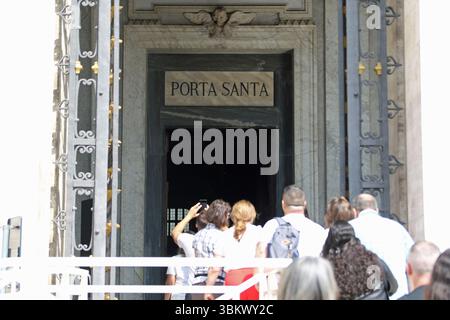 Menschenmassen gehen durch die Heilige Pforte (Porta Santa) von Santa Maria Maggiore, auch bekannt als Basilika Santa Maria Major oder Basilika Santa Maria der Großen, die eine der vier großen päpstlichen Basiliken Roms ist. Die Türen werden nur alle 25 Jahre im Rahmen des Jubiläums in Rom geöffnet. Stockfoto