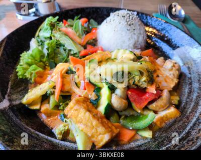 Bayern, Deutschland - 23. Juni 2025: Veganes asiatisches Gericht mit Tofu, frischem Gemüse und Reis. Das Bild zeigt eine bunte, gesunde Mahlzeit mit Currysauce, Brokkoli, Paprika, Zucchini und Karotten in einer scharfen Komposition. *** Veganes asiatisches Gericht mit Tofu, frisches Gemüse und Reis. Das Bild zeigt eine bunte, gesunde Mahlzeit mit Currysoße, Brokkoli, Paprika, Zucchini und Karotten in einer würzigen Komposition. Stockfoto