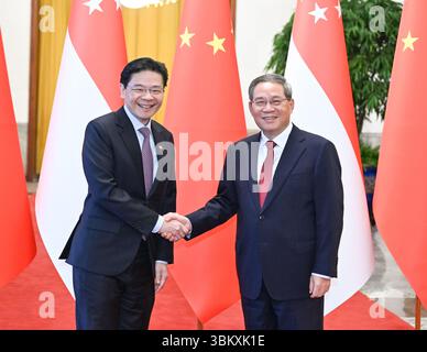 Peking, China. Juni 2025. Der chinesische Premierminister Li Qiang führt Gespräche mit dem Premierminister Singapurs Lawrence Wong, der sich auf einem offiziellen Besuch in China befindet, in der Großen Halle des Volkes in Peking, der Hauptstadt Chinas, am 23. Juni 2025. Quelle: Li Xiang/Xinhua/Alamy Live News Stockfoto