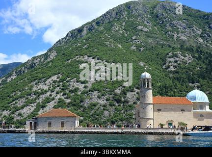 Die Kirche unserer Frau von den Felsen mit einer Bergkette im Hintergrund Stockfoto