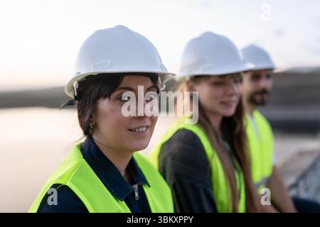 Team von Ingenieuren, die auf der Baustelle Sicherheitsausrüstung tragen Stockfoto