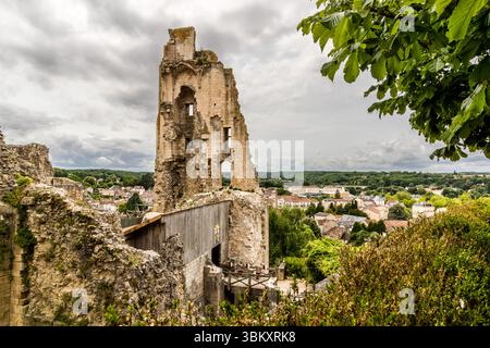 Die Ruinen des Château des Évêques (Bischofsschloss), auch bekannt als Château baronnial, erheben sich über der Oberstadt, Rue Saint-Pierre, Chauvigny, Nouvelle-Aquitaine, Frankreich. Das Schloss der Bischöfe von Poitiers ist eine von fünf Schlossruinen, die die Skyline von Chauvigny prägen. Es stammt aus dem 11. bis 15. Jahrhundert. Nach der Französischen Revolution diente es als Steinbruch. Heute zeigt die Falknershow "Les Géants du Ciel" ihre Flugvorführungen im Schloss. Die zeitlich abgenutzten Überreste überragen Teile der Stadt im Hintergrund. Stockfoto