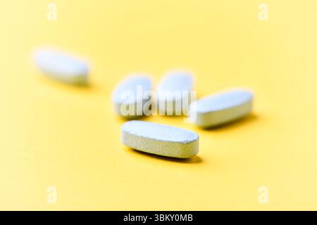Multivitamintabletten auf hellem Papierhintergrund. Nahaufnahme. Kopierbereich Stockfoto