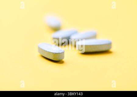 Multivitamintabletten auf hellem Papierhintergrund. Nahaufnahme. Kopierbereich Stockfoto
