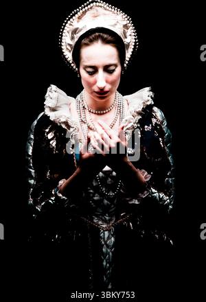 Eine Frau in historischem Gewand, möglicherweise eine Adelige oder Königsfamilie, wird vor dunklem Hintergrund dargestellt. Sie trägt einen perlenverzierten Kopfschmuck, mehrere s Stockfoto