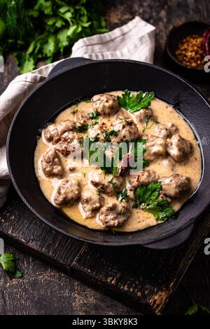Fleischbällchen in Sauerrahmsauce in einer Pfanne Stockfoto