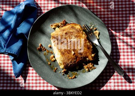 Ein Stück hausgemachter Kartoffelkuchen, serviert auf einem Teller auf einem rustikalen Tisch Stockfoto