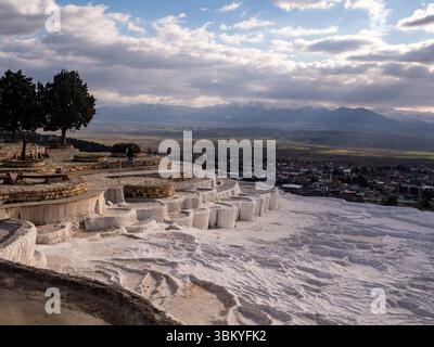 Touristen besuchen die Pamukkale-Travertines in der Türkei, eine natürliche Stätte, die für ihre Karbonatterrassen bekannt ist, die durch das strömende Thermalwasser hinterlassen werden. Stockfoto