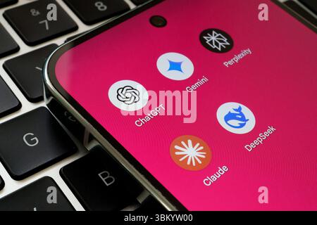 Symbole für die App ChatGPT, Gemini, Perplexity, Claude und DeepSeek AI Assistant werden auf dem Smartphone über die Laptop-Tastatur angezeigt. Stafford, Großbritannien, Juni Stockfoto