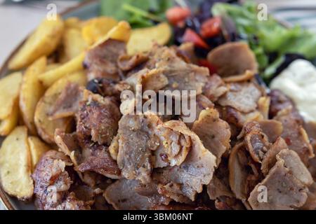 Köstlicher Gyro-Teller mit Pommes und Salat Stockfoto