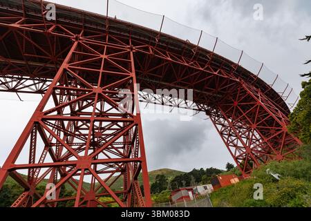 Eine Aufnahme der roten Stahlkonstruktion der Golden Gate Bridge vor einem bewölkten Himmel, die ihr kompliziertes Design und ihre Technik zeigt. Stockfoto