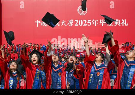 Peking, China. Juni 2025. Absolventen werfen ihre Hüte zum Feiern nach der Abschlussfeier an der Renmin University of China in Peking, Hauptstadt Chinas, 23. Juni 2025. Die Renmin University of China hielt am Montag eine Reihe von Aktivitäten für den Graduierungstag 2025 für insgesamt 8.390 Absolventen ab, die ihr Studium abgeschlossen haben und sich auf eine brandneue Lebensreise begeben werden. Quelle: Chen Shuo/Xinhua/Alamy Live News Stockfoto