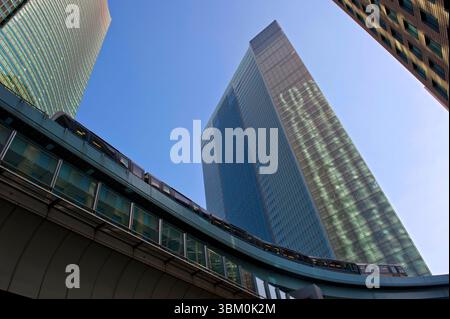 Die Yurikamome Monorail, die über den Wolkenkratzern in der Shimbashi Shiodome-Gegend von Tokio, Japan, vorbeifährt. Stockfoto