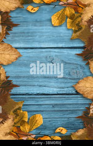 Blau lackierte Holzdielen sitzen in flachem Design mit gelben und braunen Blättern um die Kanten Stockfoto