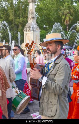 Andujar, Provinz Jaen, Andalusien, Spanien. April 2023. Männer in traditioneller Kleidung gehen und spielen eine Gitarre in einer Prozession auf einer religiösen festiva Stockfoto