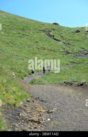 Drei Wanderer auf dem Weg nach „Schiena dell'Asino“ im Ätna Park, Sizilien, Italien (Rückansicht) Stockfoto