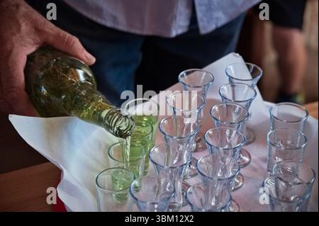 Mitte des Mannes, der Brandy aus einer Flasche gießt Stockfoto