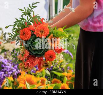 USA, Indiana, Fischer. Eine junge Frau, die Blumenstrauß auf dem Markt hält. Stockfoto