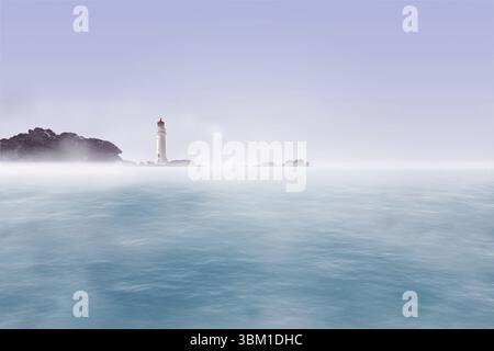 Flacher Leuchtturm mit roter Spitze steht auf einem Felsvorsprung über dem nebeligen Meer mit Inselchen Stockfoto